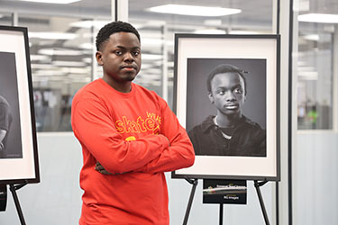 Photo of Emiliano Medellin standing in front of Portraits