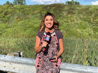 Photo of Michele Fiore sitting on road rail while holding a Fox TV Microphone