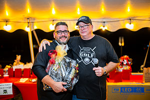 Raffle winner receiving his raffle prize from President of the Alumni Board