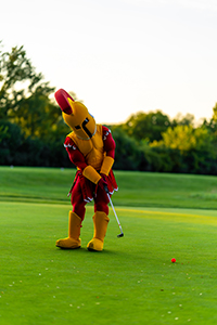 Troy the Triton College mascot putting around on the golf course 