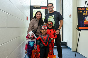 Family dressed in costume for Halloween at Trunk or Treat in space