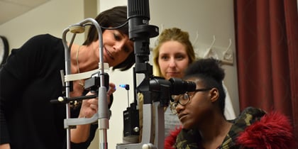 Students examining Optic Device