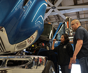 Students and Instructor looking over a truck engine