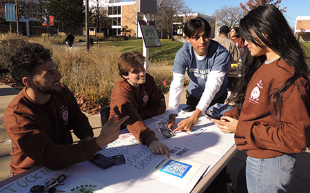 Photo of students gathered around information table