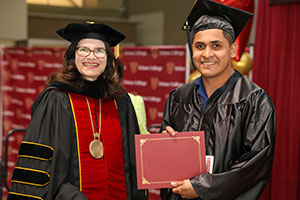 Photo of President Moore with Graduate