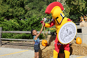 Photo of little girl giving Troy mascot a high five