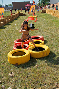 Photo of little girl racing through colored tires