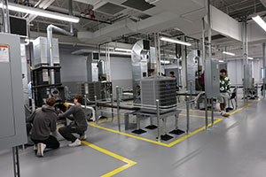 Photo of 2 students working on a HVAC unit