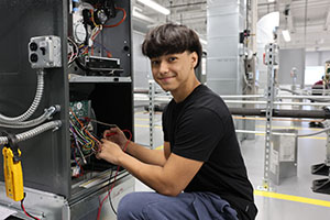 Photo of student re-wiring a HVAC unit